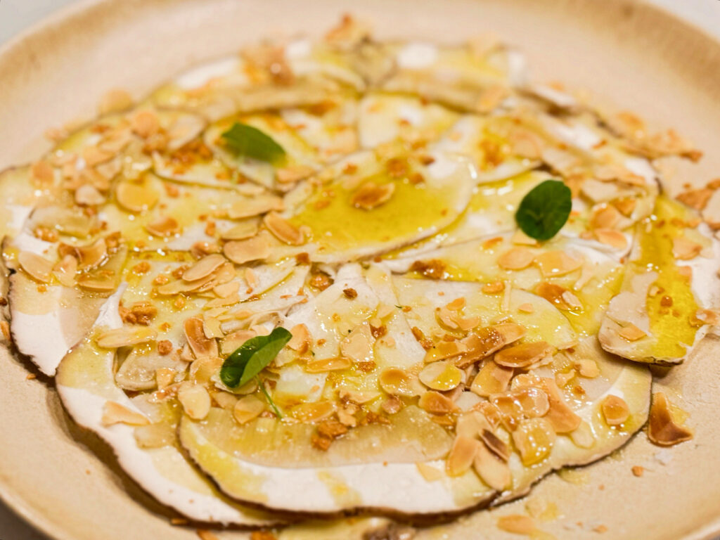 Gurumelos laminados con aceite de oliva virgen extra, almendras tostadas y ajo